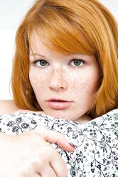 Czech ginger Mia Sollis showcases her medium tits and spreads her bald beaver