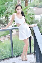 Adorable brunette hikes up her white skirt for a no panty upskirt in public
