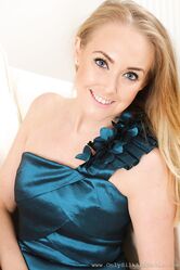 Czech mom Lucy Anne smiles while posing in hot sheer pantyhose on the sofa