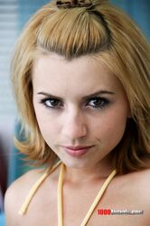 Sexy blonde teen Lexi Belle posing solo on the bed flaunting her natural tits