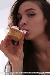 Santa enjoys her baked cupcake, playing with the creamy frosting on her lips