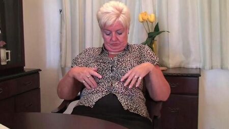The old woman undresses in front of the camera and takes out a dildo