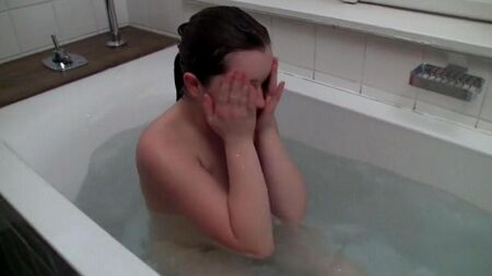 The lady masturbates a hose from a shower in a bath