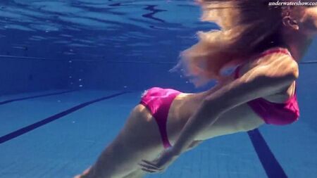 Naked beauty swims in the pool
