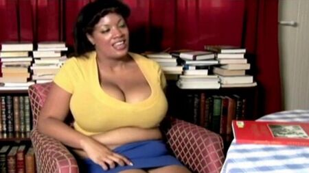 The fat woman Nigersh sits on a chair and taking off his panties strokes a pussy