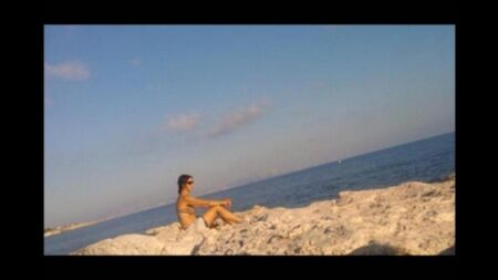 The girl sunbathes in the sun completely naked